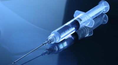 兽医为小猫注射疫苗，猫咪安静配合，诊室环境干净明亮，体现猫酷预防医学内容的专业氛围
